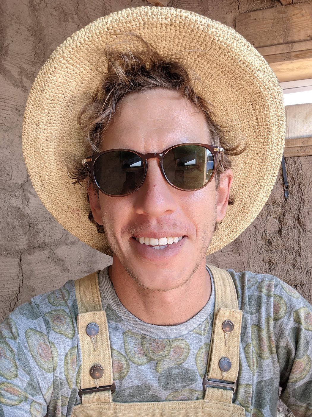 John Garland, founder of Habit Earth Homes, on site in a straw hat and overalls